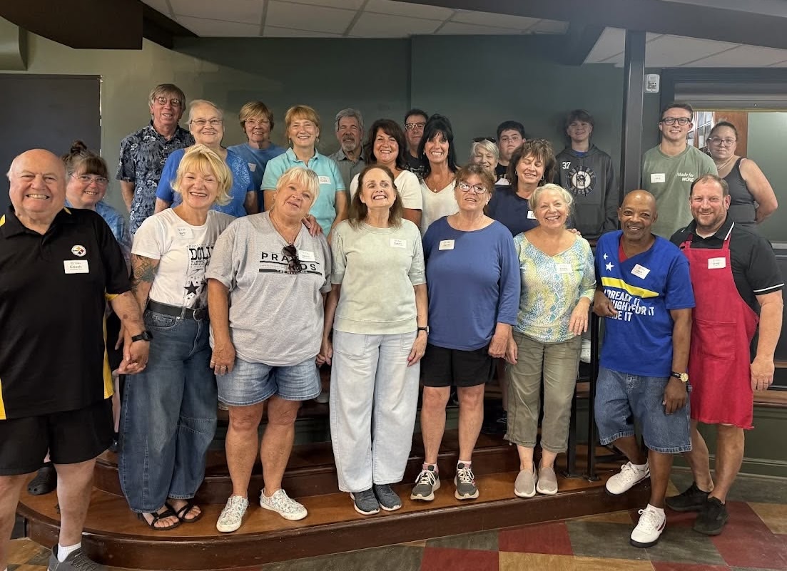 A group of Steel City Table volunteers gathered together on the steps