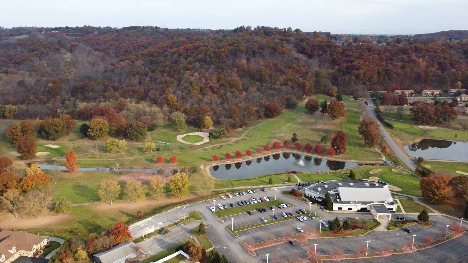 Aerial view of The Club at Shadow Lakes clubhouse, golf course and ponds in autumn